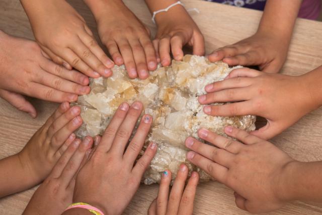 Kőzetet simogató gyerekkezek
